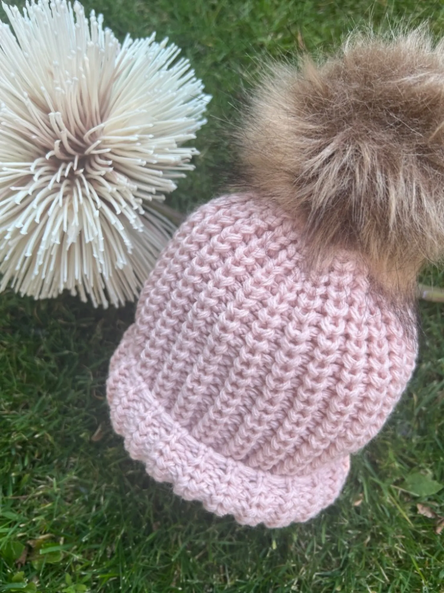 Gorrito de Bebé en punto gordito con pompón de pelo sintético.