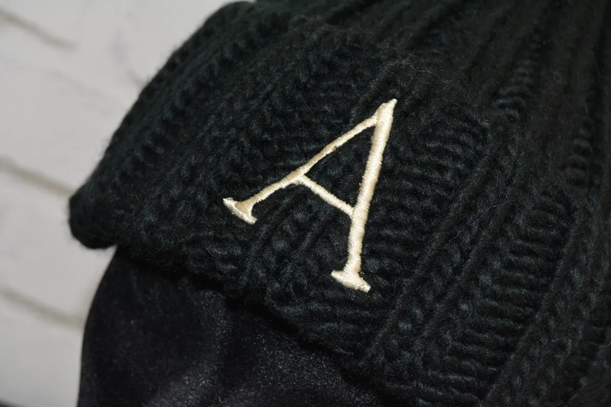 Gorro Adulto con pompón de pelo sintético extraíble color negro - inicial bordada